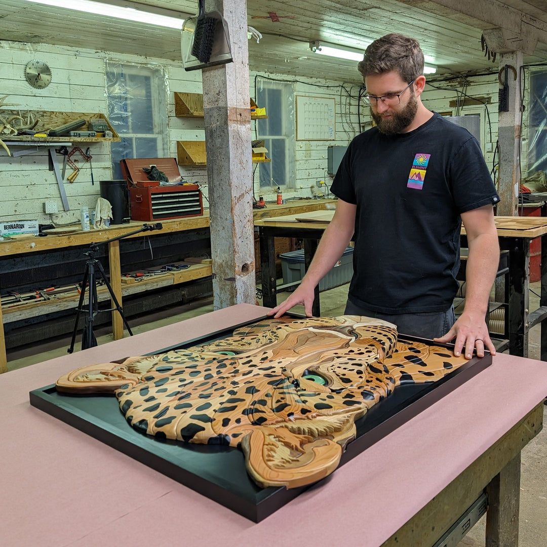 Alex Jepson crafting a unique jaguar sculpture in his studio, showcasing intricate wood carving techniques and nature-inspired art.